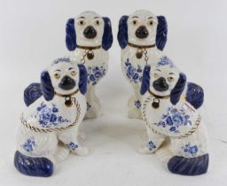 A pair of Staffordshire seated spaniels of typical form with blue printed floral decoration,