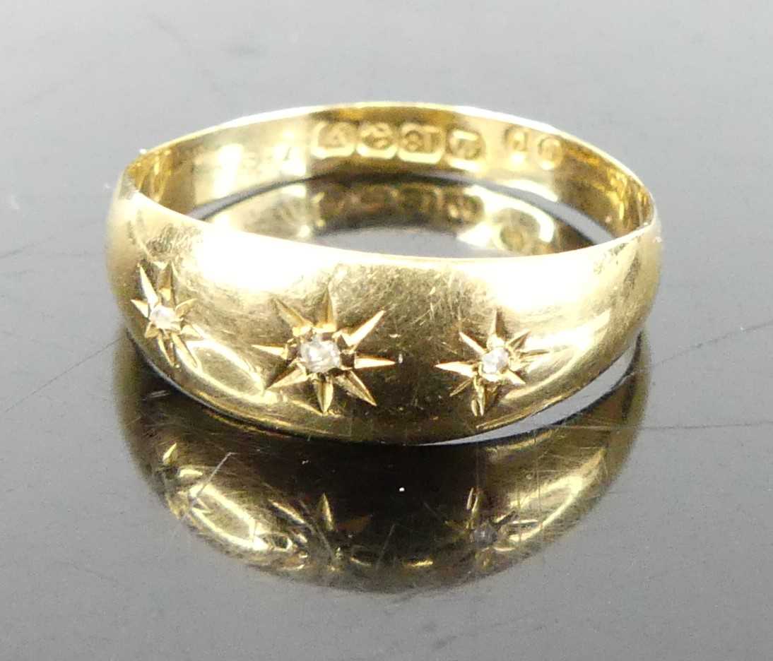An 18ct gold band ring, 'gypsy' set with three diamond points, 2.1g, size P