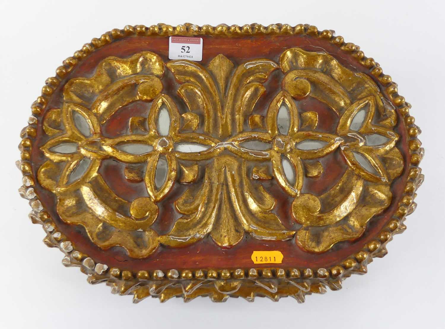 A carved softwood and polychrome painted table top casket of oval form having inset mirrored panels,
