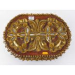 A carved softwood and polychrome painted table top casket of oval form having inset mirrored panels,