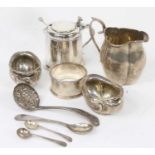 A collection of silver, to include a drum shaped mustard, cream jug, napkin ring and sifting