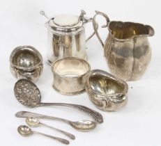 A collection of silver, to include a drum shaped mustard, cream jug, napkin ring and sifting