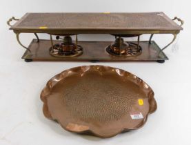 An early 20th century copper warming plate, the rectangular top with hammered finish, having twin