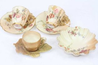 A pair of Royal Worcester blush ivory 1334 pattern coffee cans and saucers, decorated with