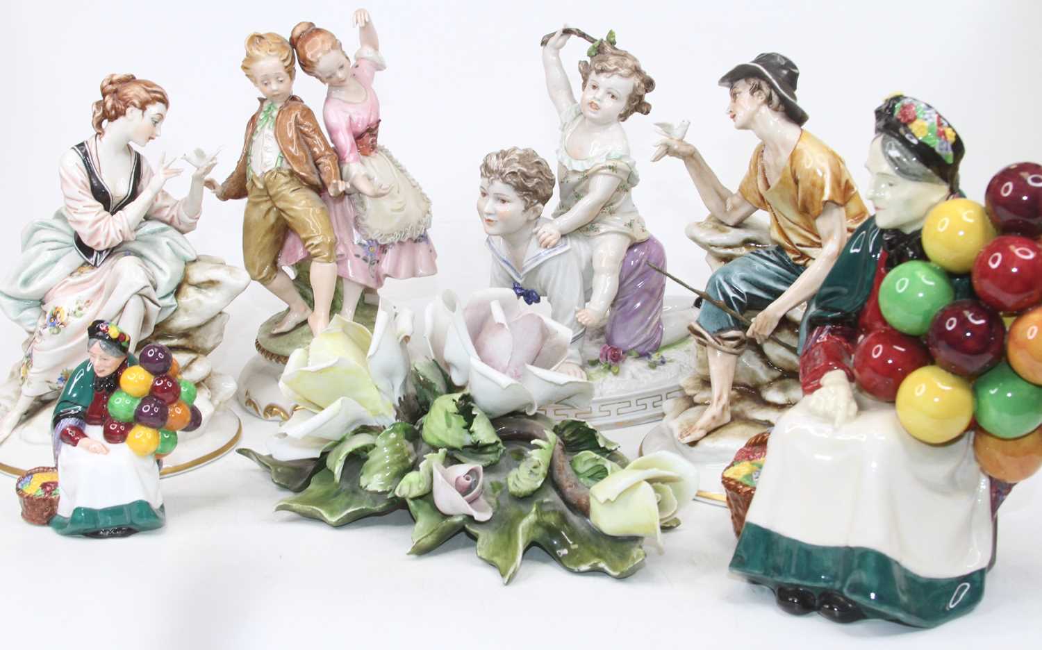 A Royal Doulton figure The Old Balloon-seller, h.19cm; together with another smaller example, h.9cm;