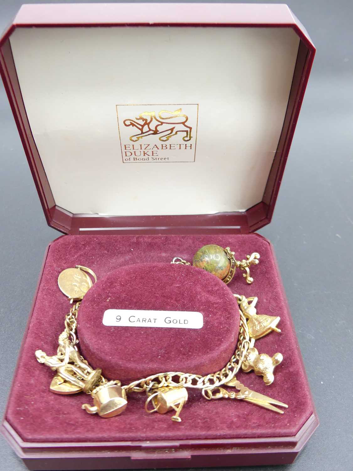 A modern 9ct gold bracelet, containing assorted principally 9ct gold charms, gross weight 20.1g