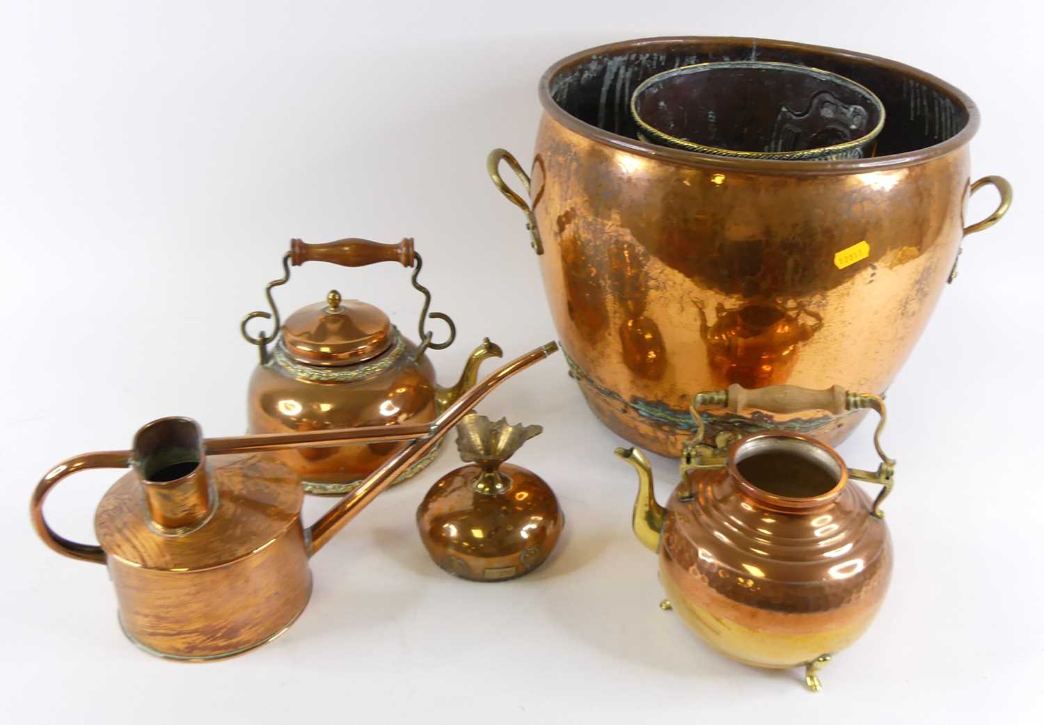 A large copper jardiniere of riveted construction having twin brass handles, raised on brass paw