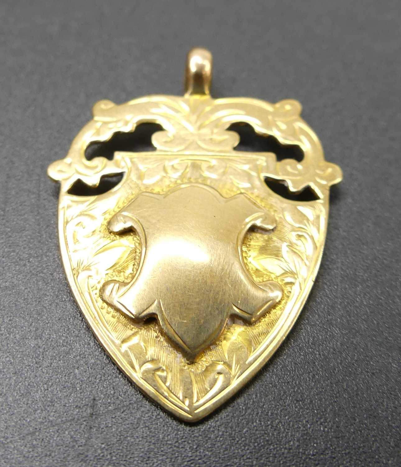 A 9ct gold shield shaped medallion pendant, sponsor JWT, 4.7g, 31mm