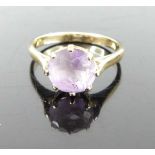 A yellow metal and round cut amethyst set dress ring, unmarked but tests as approx 9ct gold, 2.2g,