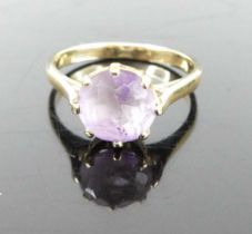 A yellow metal and round cut amethyst set dress ring, unmarked but tests as approx 9ct gold, 2.2g,