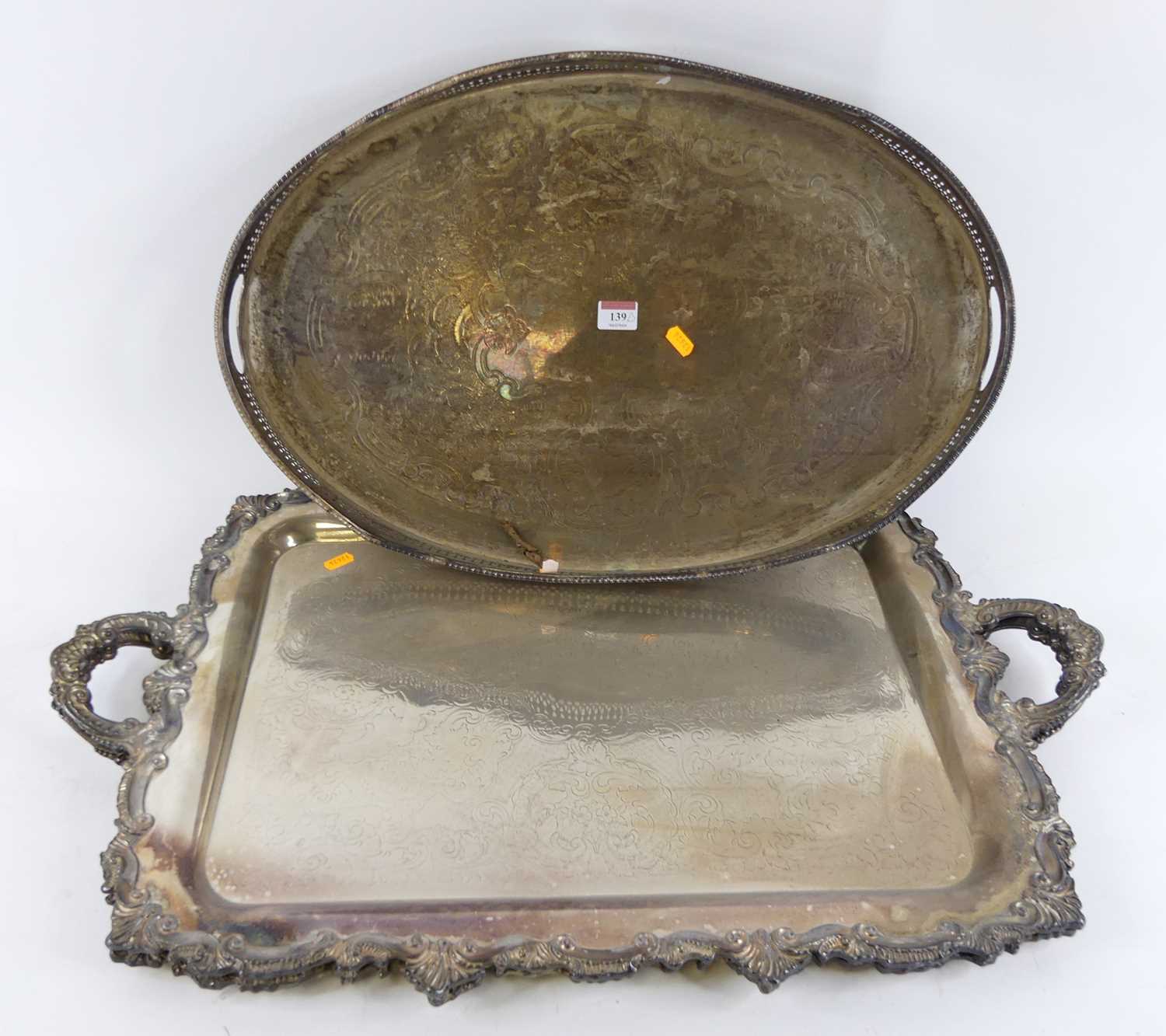 A pair of silver plated serving trays, having twin handles and scrolled borders, w.76cm; together