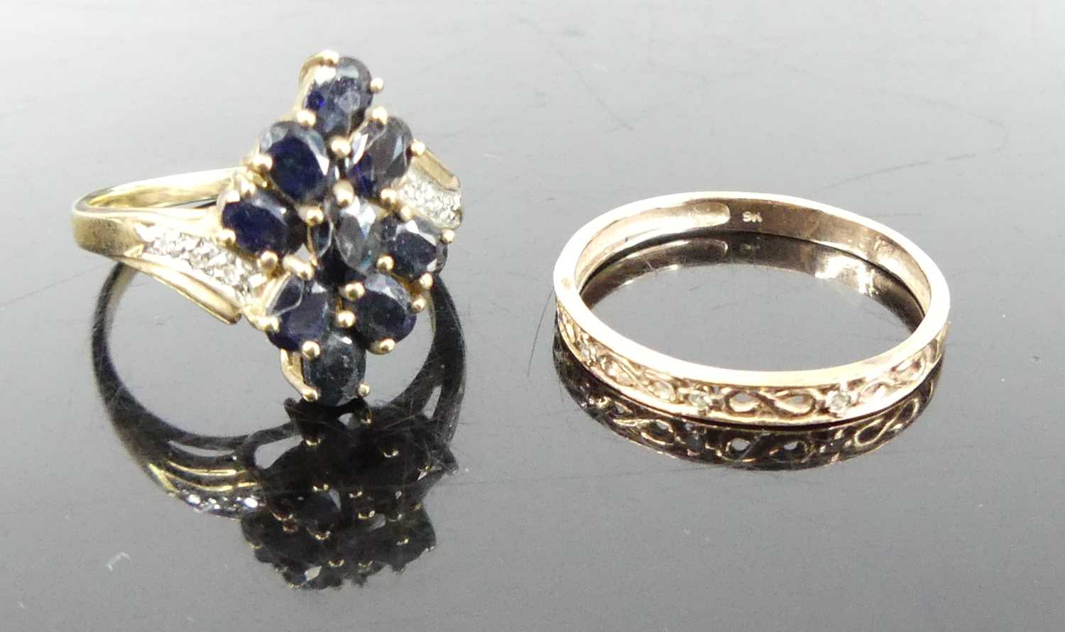 A modern 9ct gold and sapphire cluster ring, the shoulders each pavé set with three smaller white