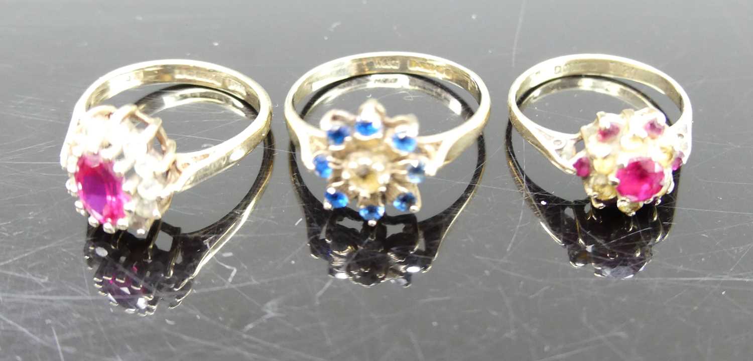 A 9ct gold, blue and white paste set cluster ring, size N; together with two 9ct gold ruby and white