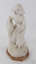 A carved white marble figure of a young girl shown seated upon an octagonal rouge marble plinth,