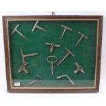 A framed and glazed display of various vintage mixed region railway carriage keys to include LNWR,