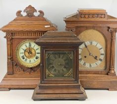 An early 20th century continental oak mantel clock, h.32cm; together with two other similar