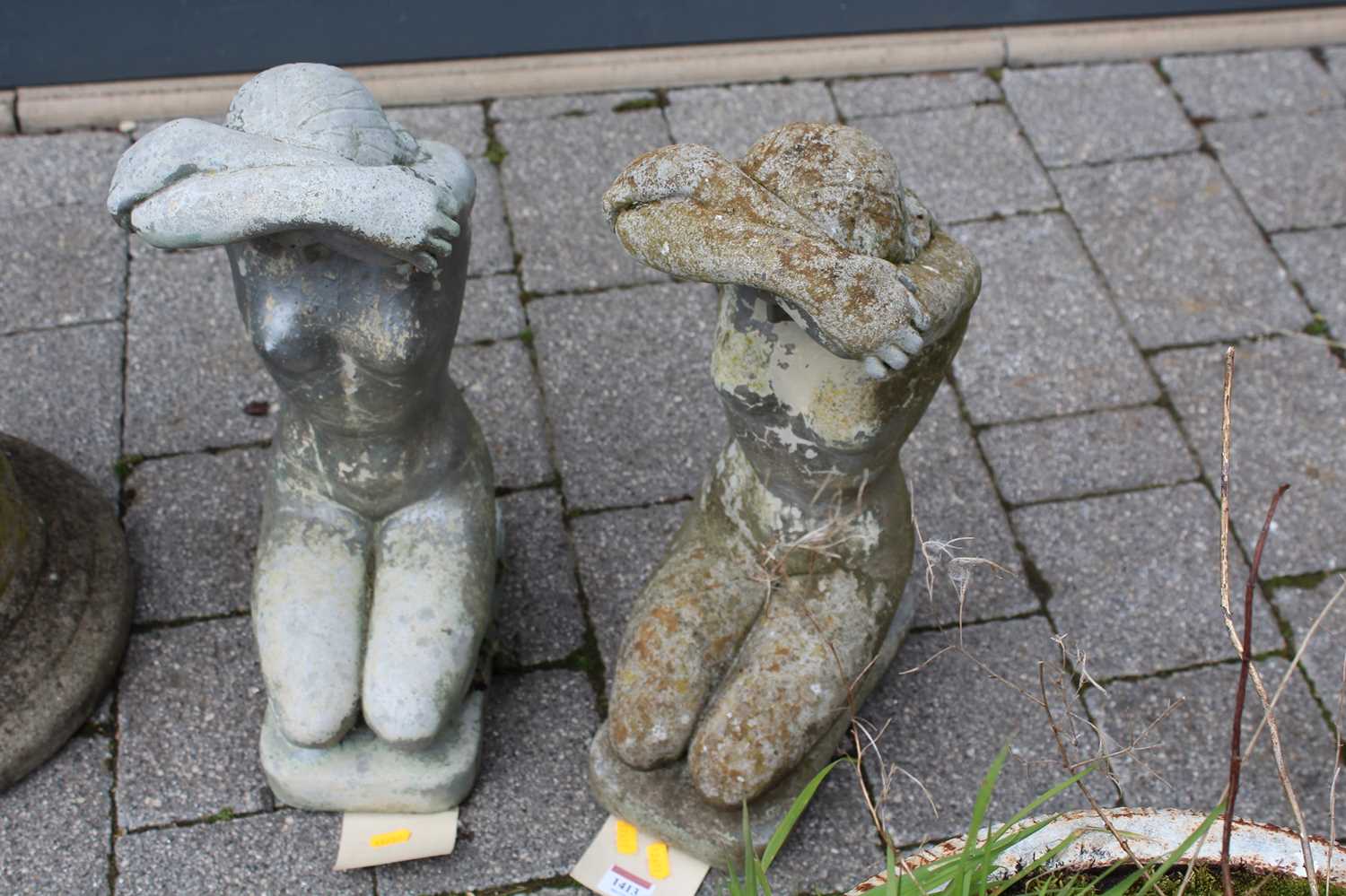 A pair of reconstituted stone garden figures of kneeling nude maidens, height 51cm