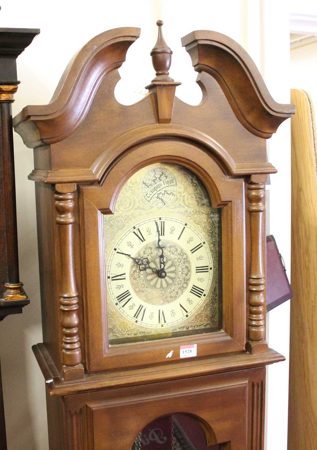 A reproduction faux walnut long case clock, having three train musical movement, height 185cm (