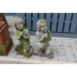 A pair of reconstituted stone garden figures, each modelled as a kneeling young girl, to