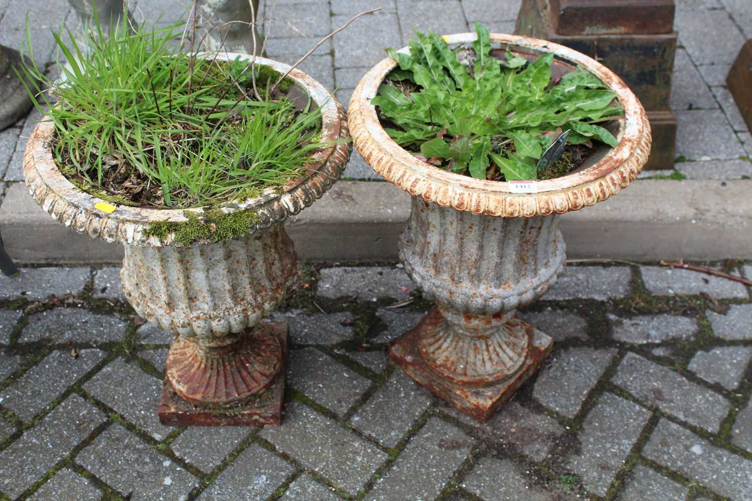 A pair of white painted cast iron pedestal garden urns, in the classical taste, height 50cm