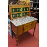 A late Victorian satin wood and variegated marble topped and tiled inset single door wash stand,