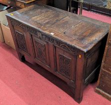 An 18th century provincial oak three panelled hinge top coffer, later relief carved to front,