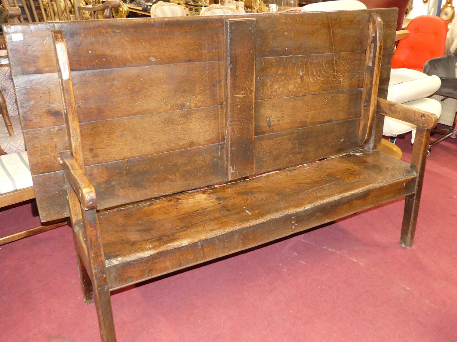 An antique joined oak and elm long bench settle, having a fold-over top, length 181cm Some losses