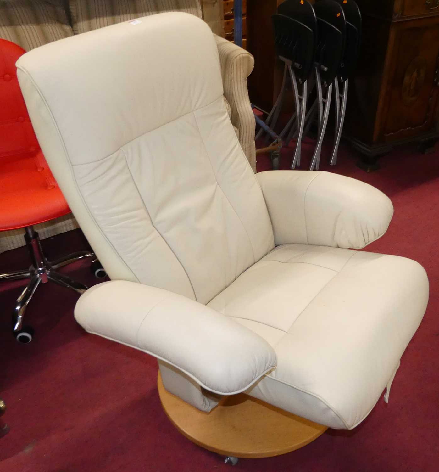 A contemporary cream leather upholstered swivel armchair, with matching footstool, on circular - Image 2 of 3