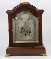 An early 20th century mahogany cased bracket clock, having a silvered arched dial, three-train