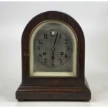 An early 20th century oak dome topped mantel clock, having an eight-day spring-driven movement