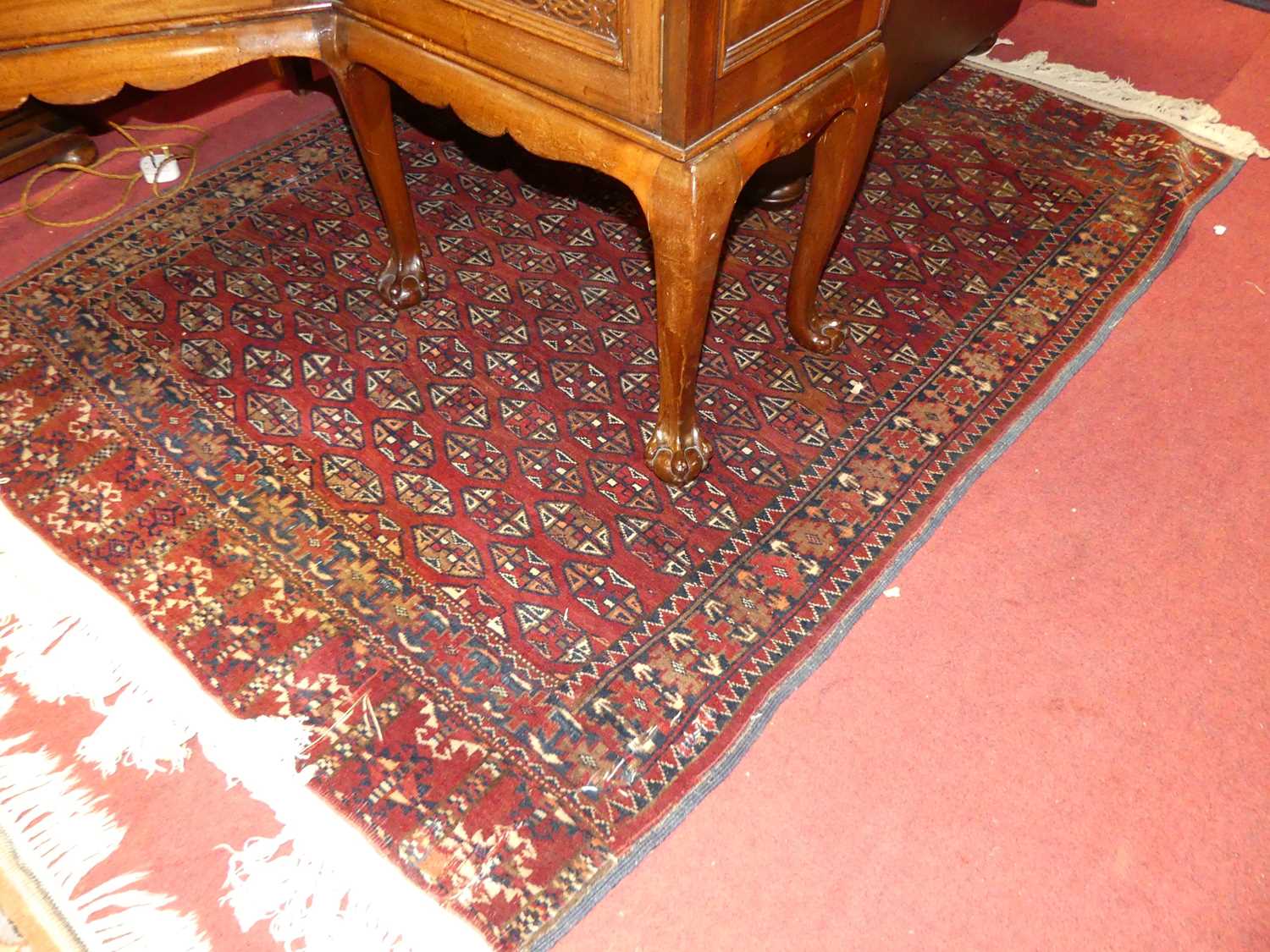 A Persian woollen red ground Bokhara rug, with stylised geometric design and flat weave ends, 165