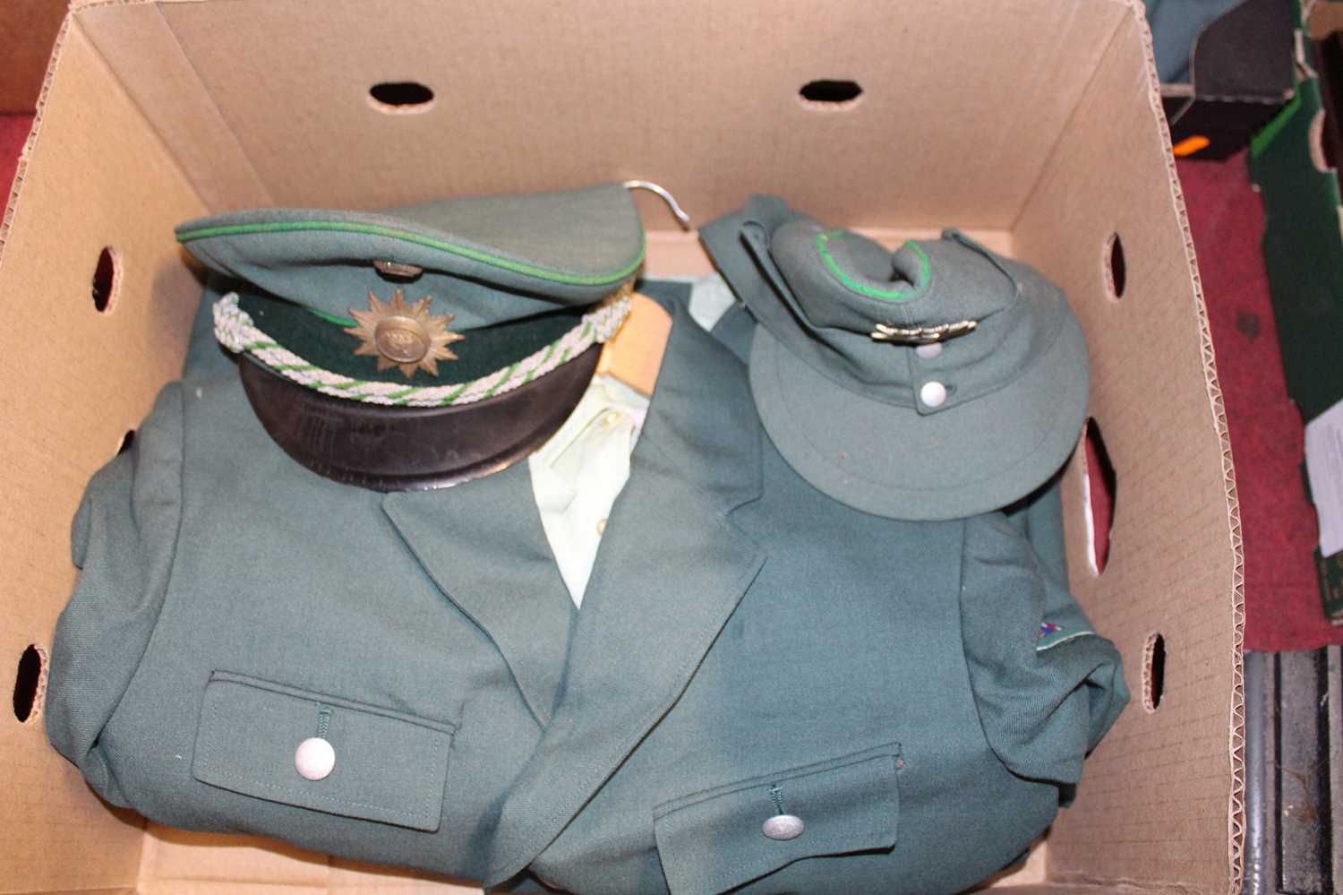 Two boxes of assorted police uniforms, to include German Bundesgrenzchutz tunic and cap etc