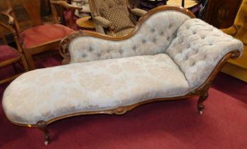 A mid-Victorian figured walnut framed and blue floral buttoned damask upholstered chaise-longue,