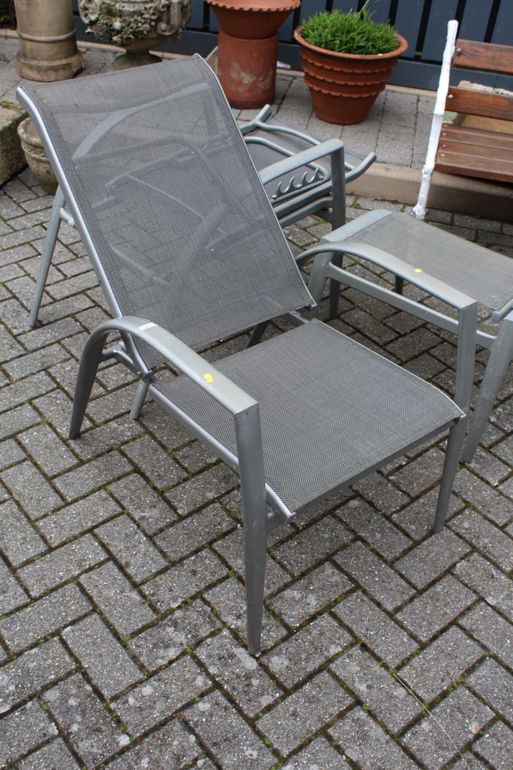 A pair of contemporary metal garden reclining armchairs, with matching foot stools