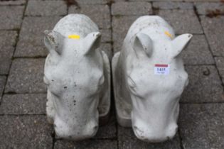 A pair of white painted reconstituted stone garden figural ornaments of horses' heads, length 38cm