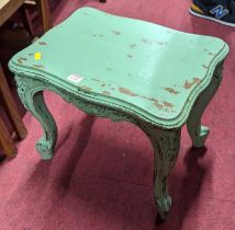 A French green painted low occasional table, having serpentine edge, floral carved cabriole