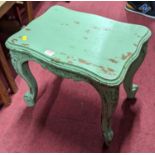 A French green painted low occasional table, having serpentine edge, floral carved cabriole