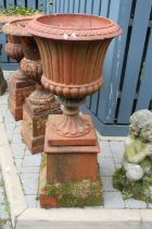 A terracotta fluted pedestal garden urn, raised on a square stepped base, overall height 123.5cm