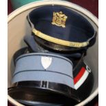 Two boxes of assorted headwear, to include German Military Police visor caps etc