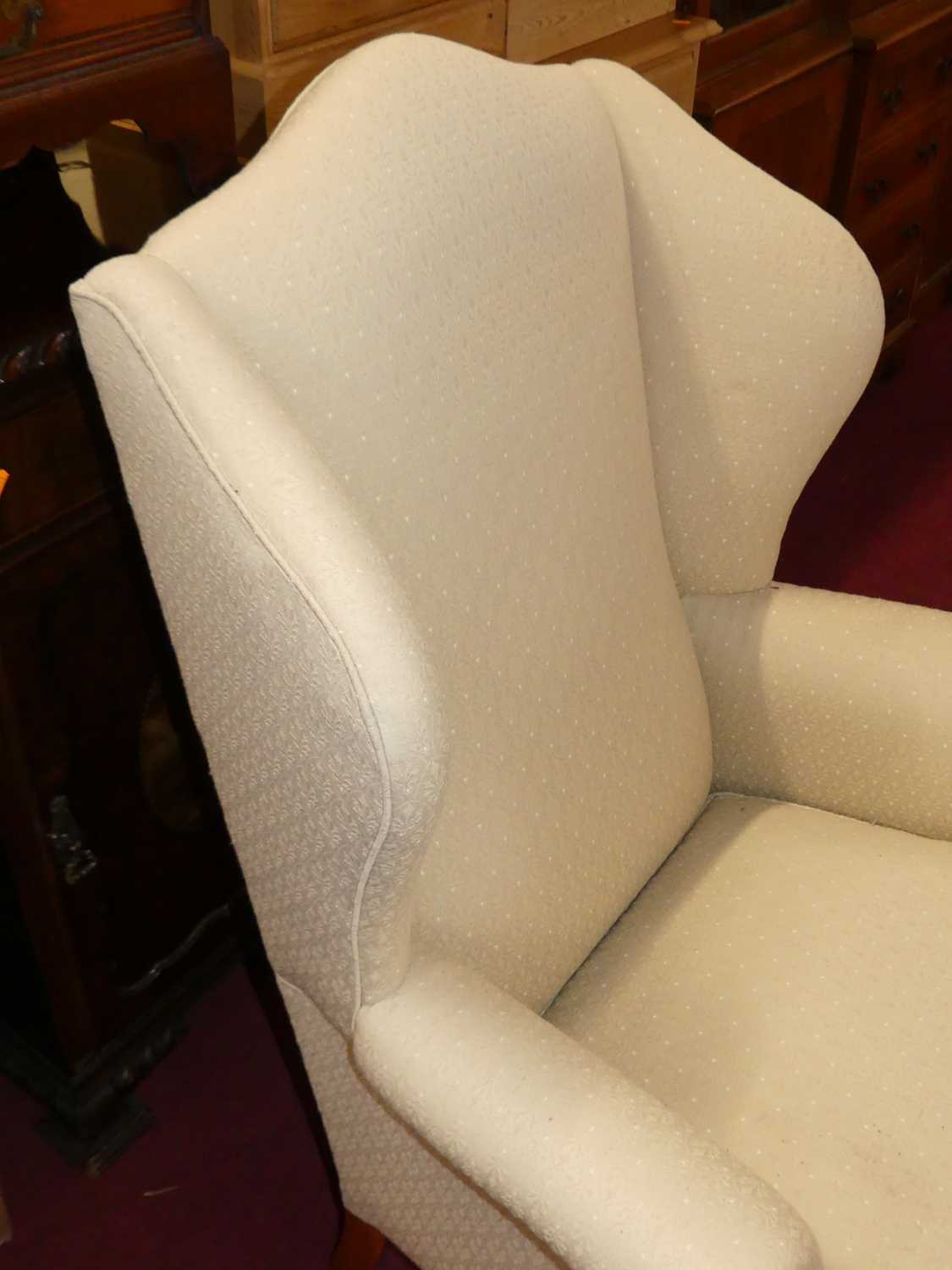 A contemporary cream floral fabric upholstered wingback scroll armchair, having squab cushion and - Image 3 of 4