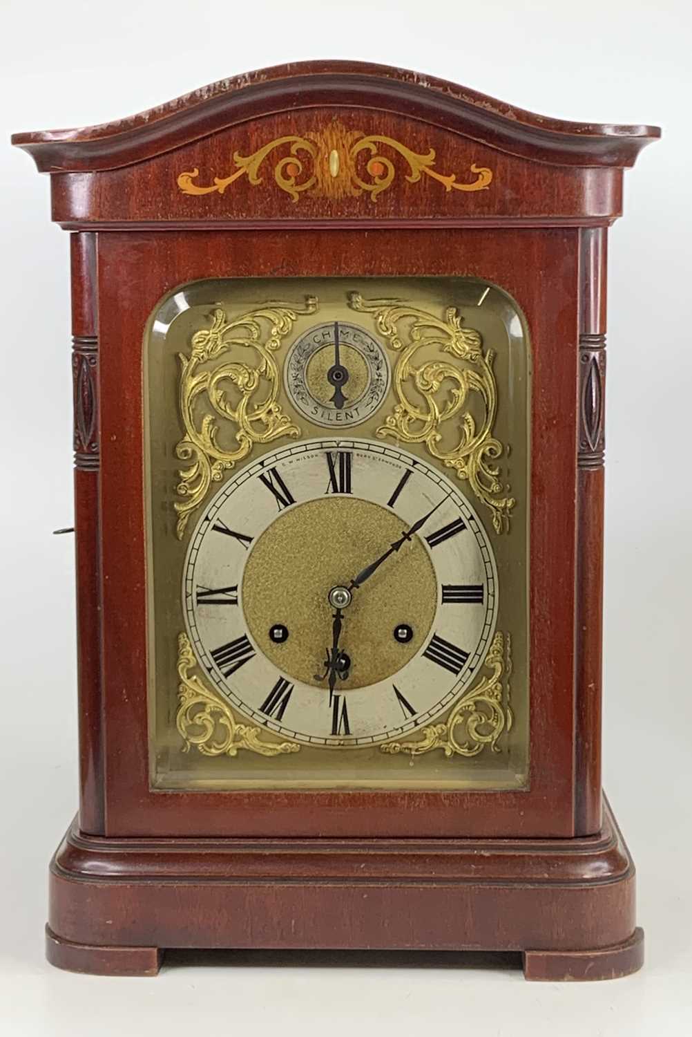 An early 20th century mahogany and inlaid mantel clock, the silvered chapter ring signed by the