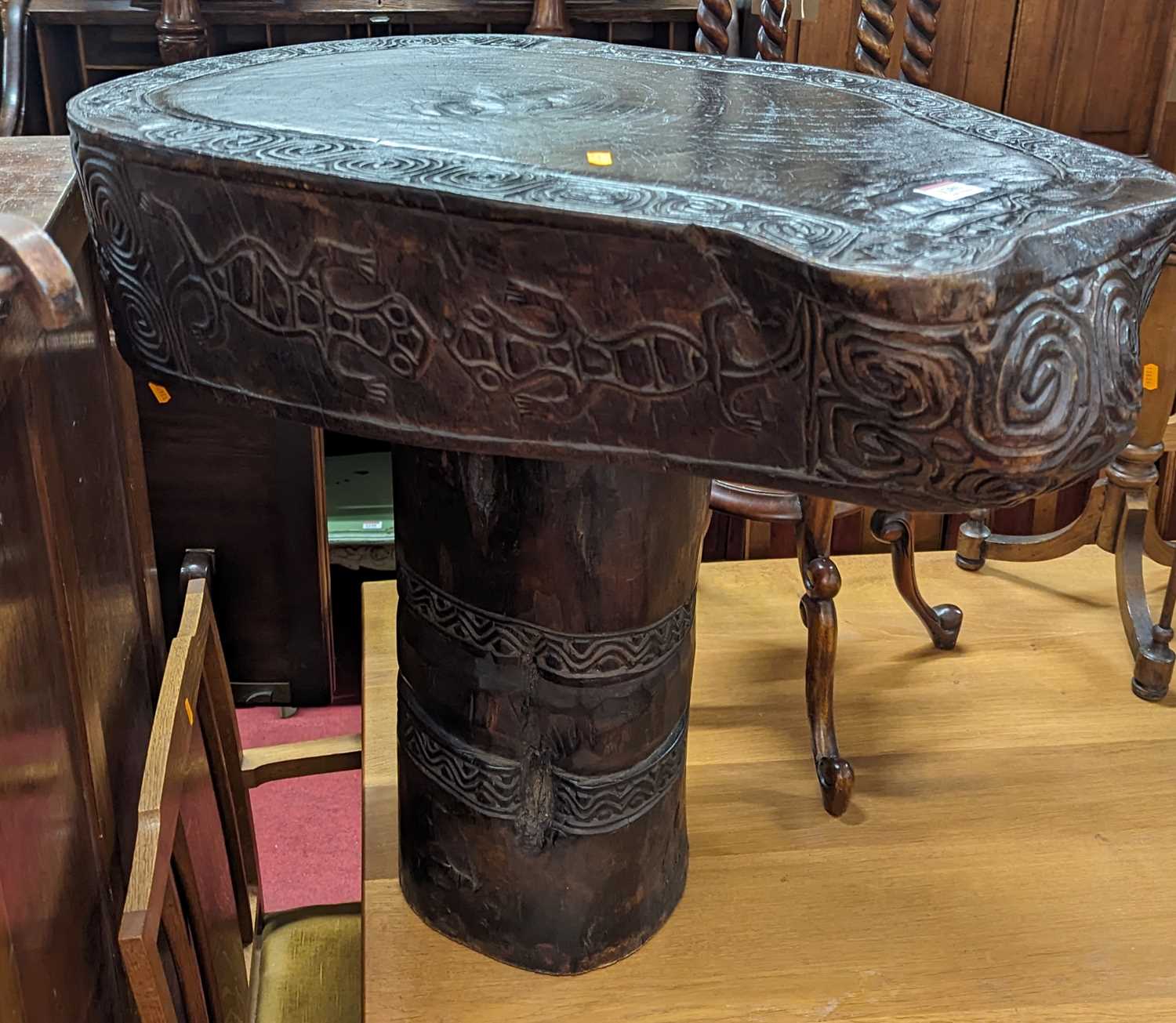 An Indonesian Saur tree slab table from the island of Timor, with stylised carved banded design,