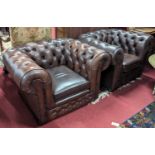 A pair of contemporary tan leather buttoned and further brass studded Chesterfield armchairs by