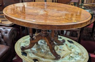 A mid-Victorian figured walnut oval tilt-top pedestal breakfast table, raised on fluted and acanthus