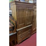 A rustic pine linen cupboard, the twin upper doors over base fitted with four long graduated