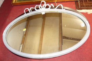 A painted composition framed oval wall mirror, w.80cm; together with a bevelled oval example (2)