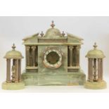 A circa 1900 onyx three-piece clock garniture, the clock of architectural outline and having