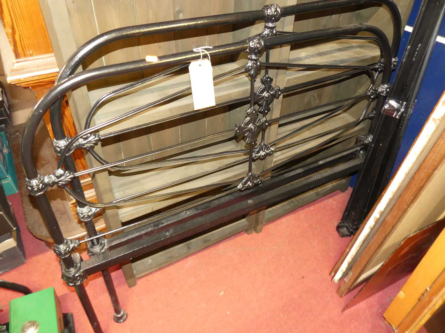 A late Victorian black painted wrought iron three-quarter size bedstead, with iron side rails