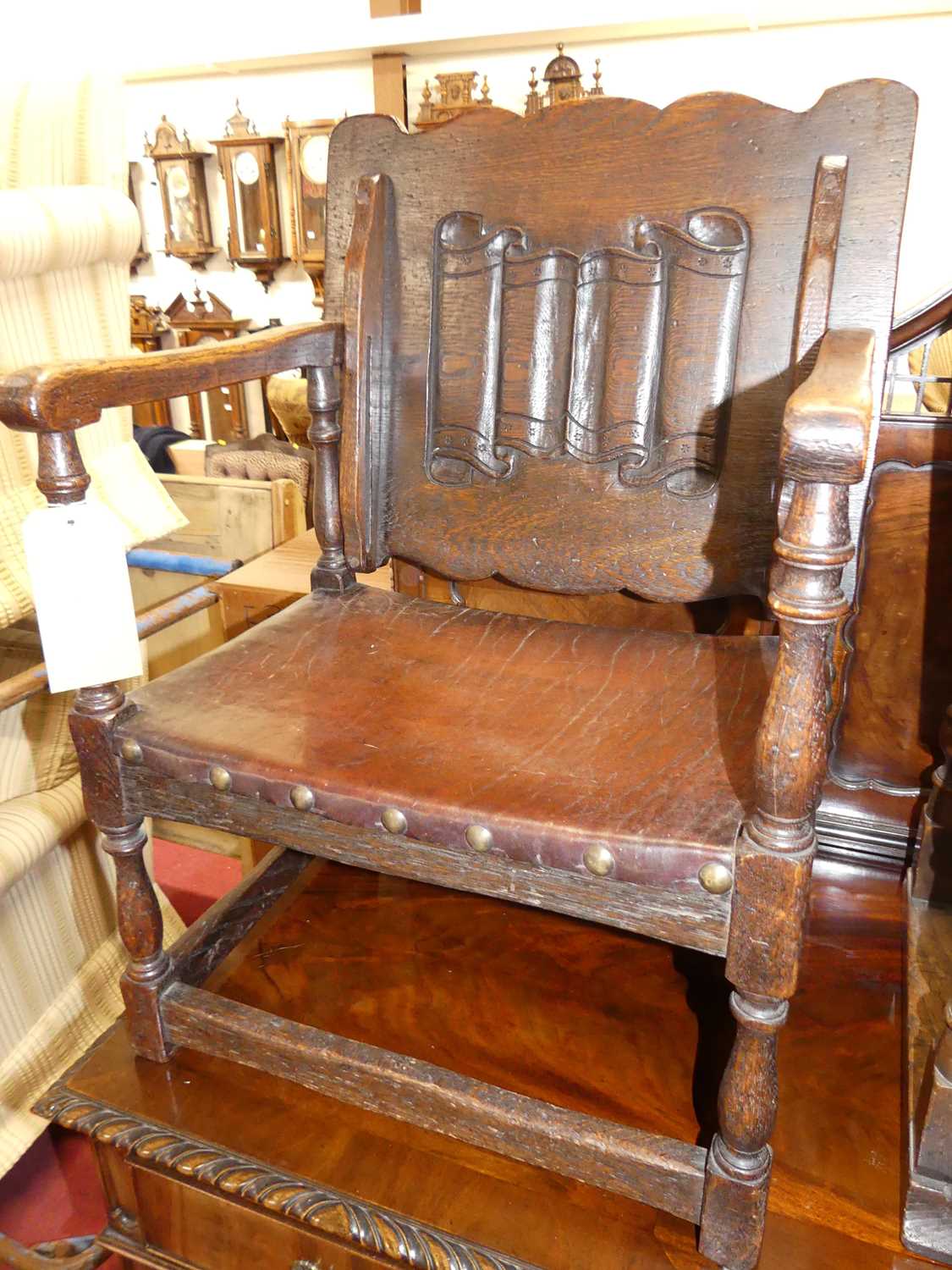 A joined oak fold-over monks chair, having a studded tan leather seat, w.52cm