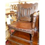 A joined oak fold-over monks chair, having a studded tan leather seat, w.52cm